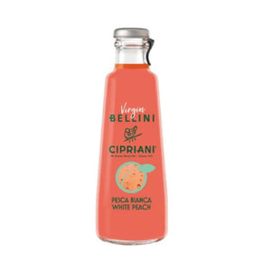 A clear glass bottle of CIPRIANI ALCOHOL-FREE BELLINI by INTERNATIONAL GOURMET FOODS, with pink liquid and a label featuring "Pesca Bianca White Peach" and a peach illustration, highlights its alcohol-free white peach cocktail.