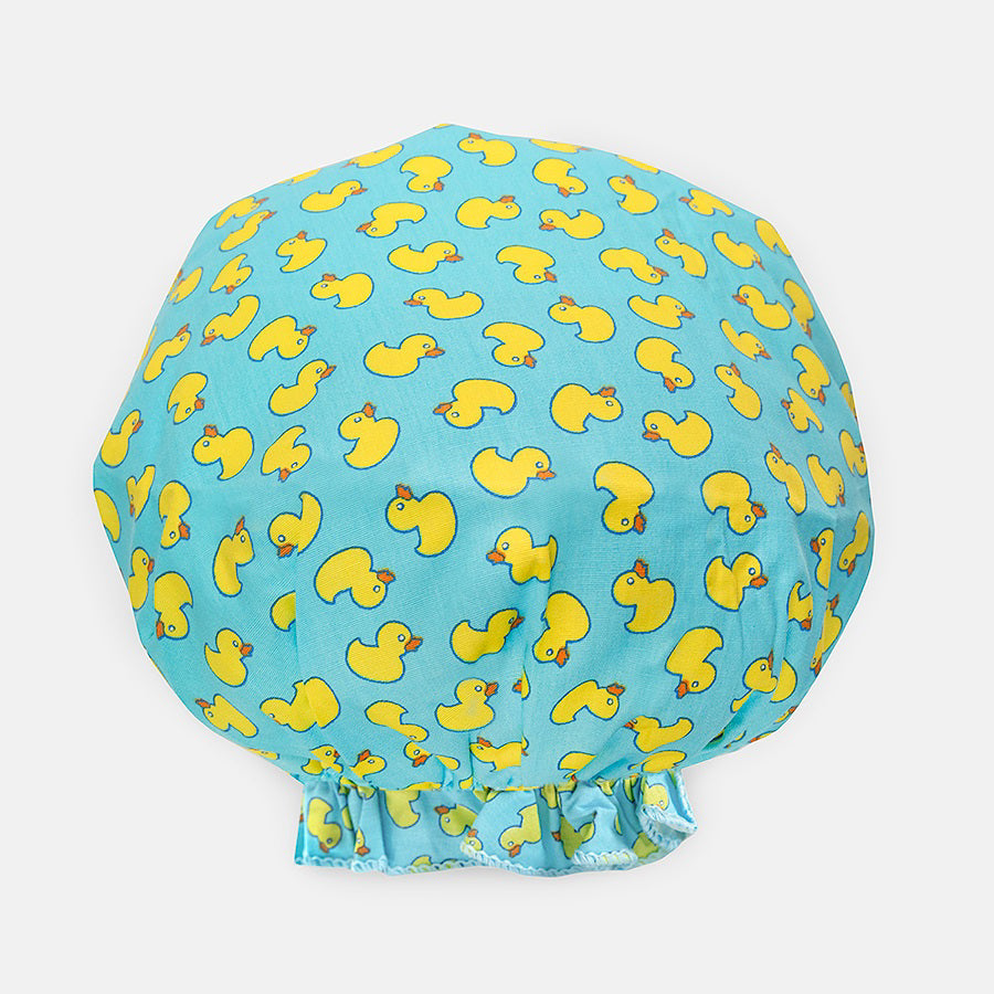 Introducing the BOUFFANT SHOWER CAP from BATH ACCESSORIES COMPANY! This stylish shower cap showcases a vibrant design of colorful macarons in shades of pink, purple, yellow, and brown against a lively green background. It features a waterproof inner layer to keep your hair dry and an elasticated bottom for a secure and comfortable fit.