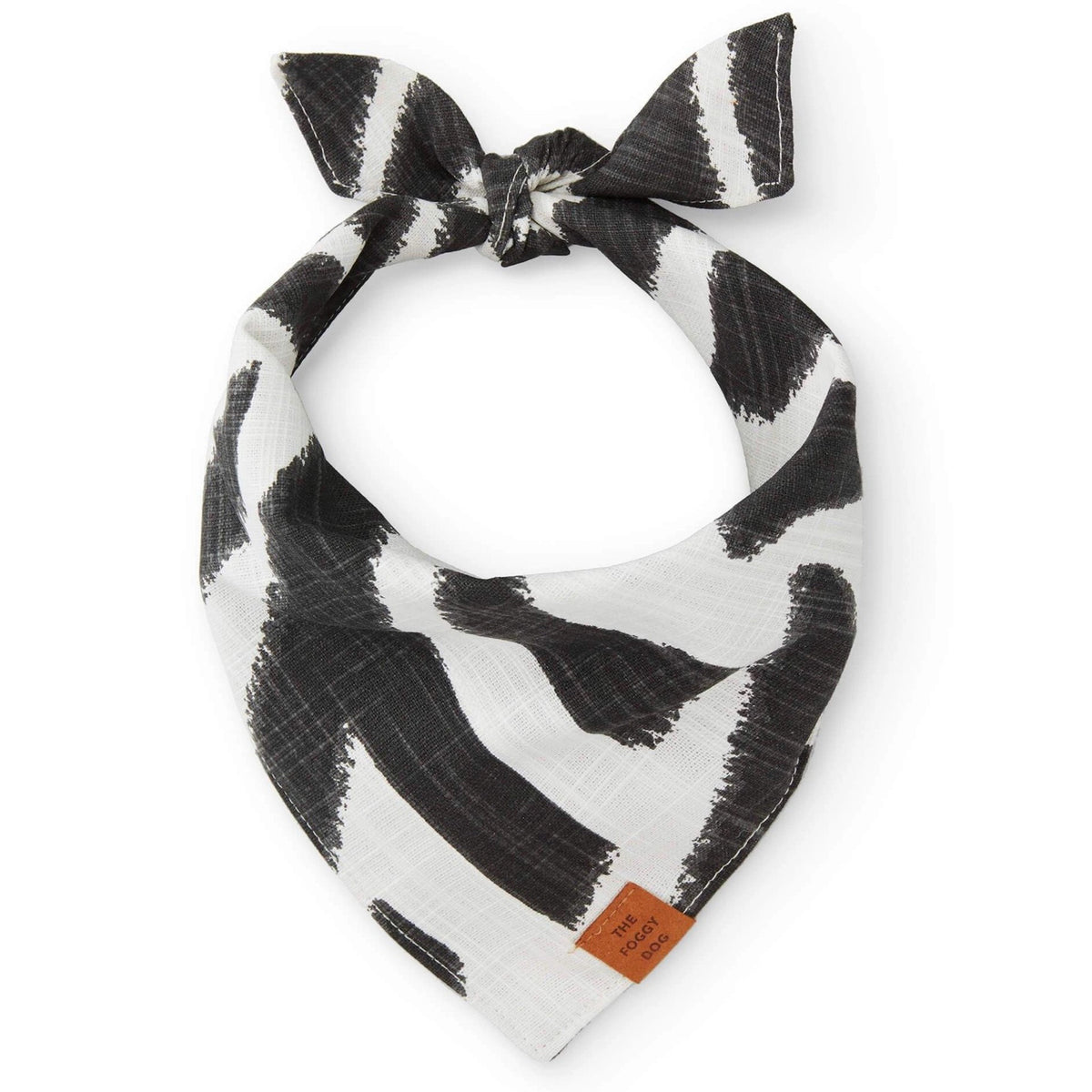 Introducing THE FOGGY DOG&#39;s BANDANA (L, EBONY ZEBRA), a handmade black and white dog bandana featuring a stylish modern abstract brushstroke pattern. Crafted in San Francisco, this triangular bandana is made from lightweight fabric and ties easily at the top. A small brown leather tag on one corner reads &quot;THE FOGGY DOG.