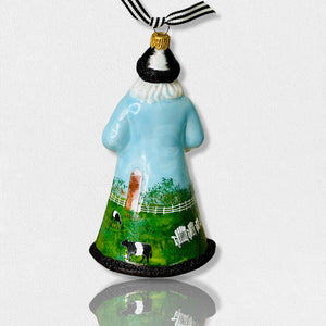 The Fearrington Signature Collection - Handmade Santa Ornament by Joy to the World Collectibles features a bearded figure in a blue robe adorned with farm scenes, including sheep, chickens, and a white fence. This hand-painted keepsake from Fearrington Village is topped with a gold cap and includes a black-and-white striped ribbon for hanging.