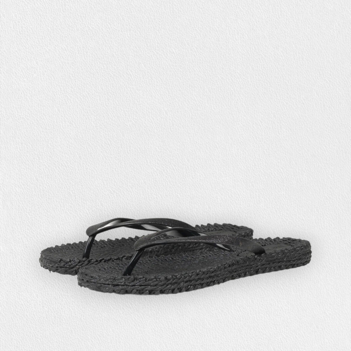 The ILSE JACOBSEN - CHEERFUL FLIP FLOP IN BLACK from Lines of Denmark features textured air rubber soles and simple thong-style straps, set against a plain white background. These flip-flops offer a comfortable fit with their casual, minimalist design.