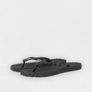 The ILSE JACOBSEN - CHEERFUL FLIP FLOP IN BLACK from Lines of Denmark features textured air rubber soles and simple thong-style straps, set against a plain white background. These flip-flops offer a comfortable fit with their casual, minimalist design.