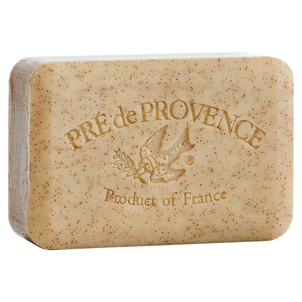 The HONEY ALMOND BAR SOAP, a 250g rectangular bar from EUROPEAN SOAPS, LLC, features speckled French-milled soap with "PRE de PROVENCE" engraved on it and an image of a bird holding an olive branch. "Product of France" is engraved below the bird. Enriched with shea butter, the soap has a natural beige color with small visible particles.