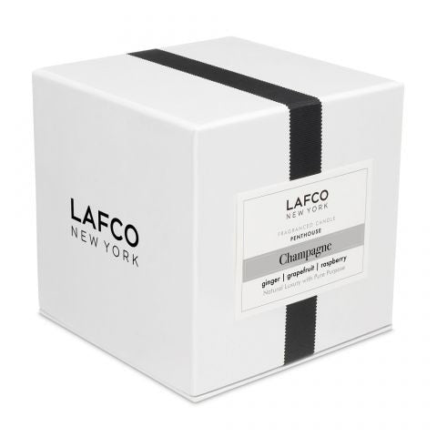 The LAFCO - CHAMPAGNE Penthouse 6.5oz candle holder by LAFCO is a small cylindrical piece featuring a frosted white exterior and a slightly transparent base. It casts a soft shadow to the right on a plain white background, evoking the refreshing essence of grapefruit.