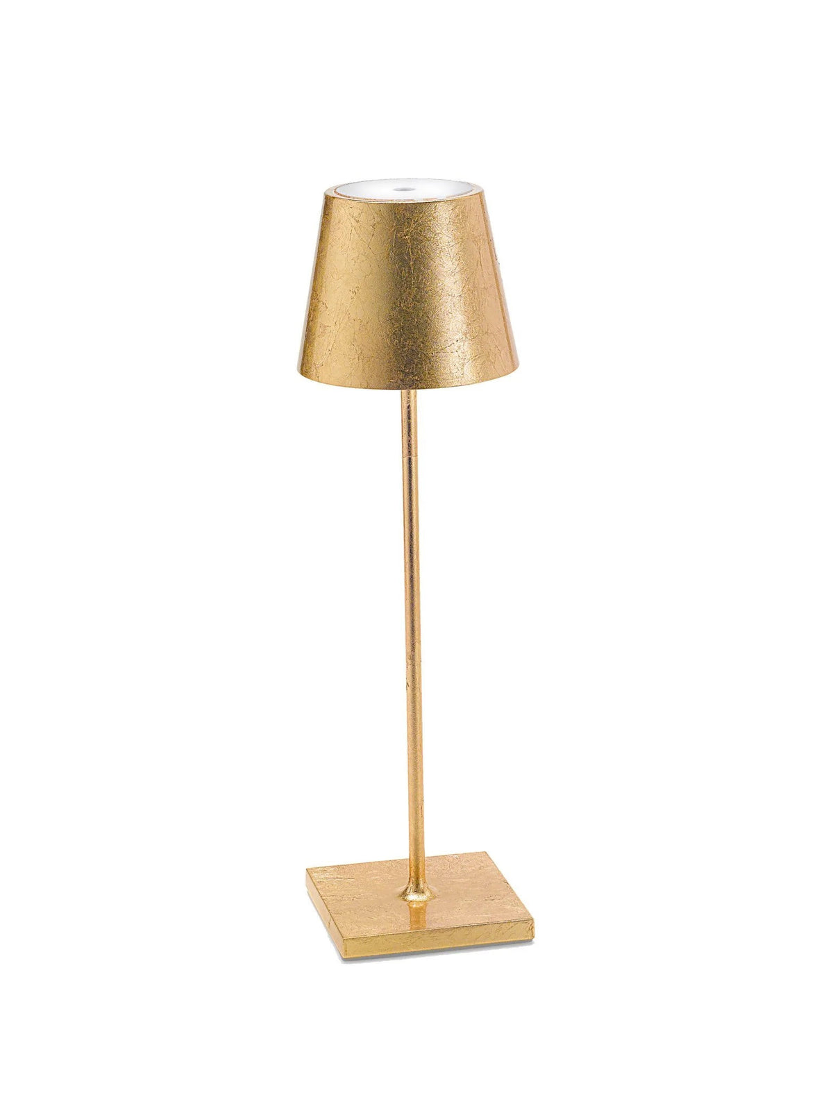 The POLDINA PRO GOLD LEAF CORDLESS LAMP by ZAFFERANO AMERICA, LLC is a sleek and modern gold table lamp with a slim stem, a tapering lampshade, and a square base. This portable rechargeable lamp features a textured finish on both the lampshade and base, adding elegance to its minimalist design. It&#39;s perfect for cordless illumination in both indoor and outdoor settings.