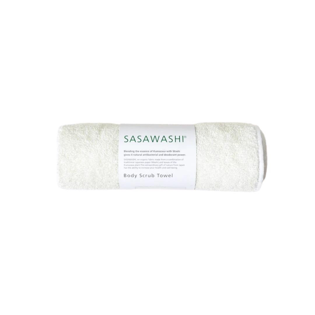 A rolled-up, white body scrub towel labeled "SASAWASHI BODY SCRUB TOWEL" by MORIHATA is on display. The towel is packaged with a simple white and green label, highlighting its unique Sasawashi fabric blend of Japanese washi paper and deodorizing kumazasa plant fibers, offering natural exfoliation and antibacterial benefits.