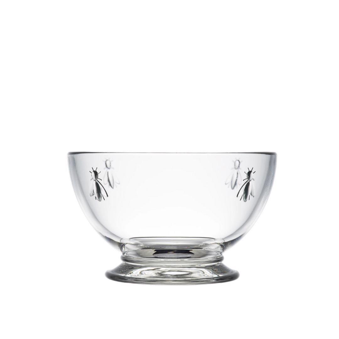 The LA ROCHERE BEE BOWL features clear glass with small embossed bees around the sides and a round base. This elegant, dishwasher-safe bowl is set against a white background.