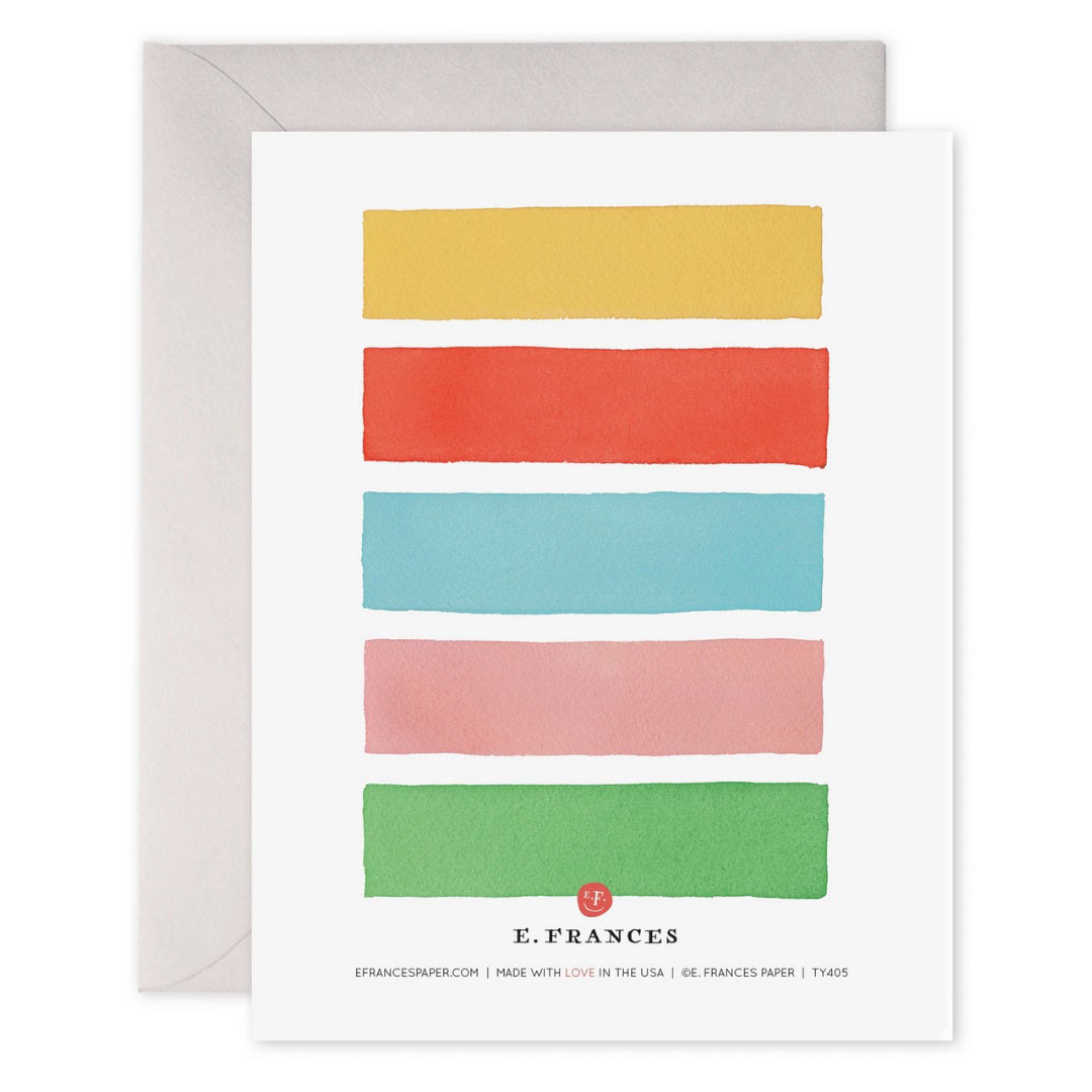 The E. FRANCES PAPER - COLOR BARS THANK YOU CARD showcases five horizontal watercolor stripes in green, pink, blue, red, and yellow. The words "thank you very much" shimmer with gold foil on the blue stripe and come elegantly placed on an envelope.