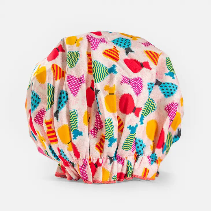 Introducing the BOUFFANT SHOWER CAP from BATH ACCESSORIES COMPANY! This stylish shower cap showcases a vibrant design of colorful macarons in shades of pink, purple, yellow, and brown against a lively green background. It features a waterproof inner layer to keep your hair dry and an elasticated bottom for a secure and comfortable fit.