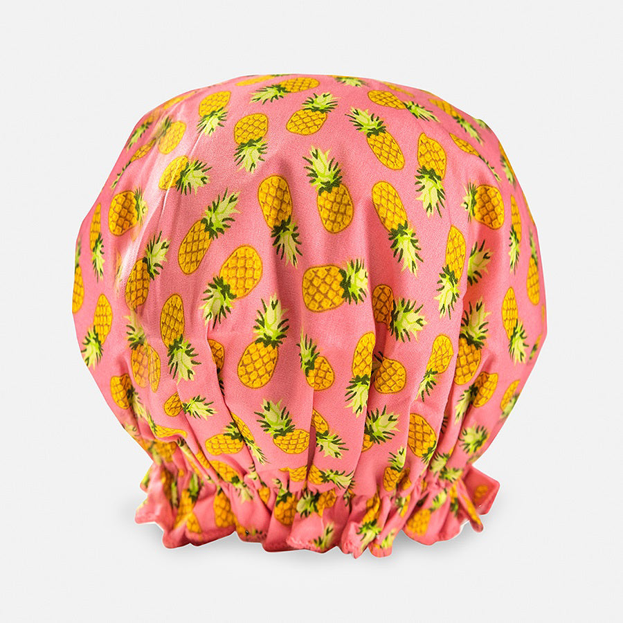 Introducing the BOUFFANT SHOWER CAP from BATH ACCESSORIES COMPANY! This stylish shower cap showcases a vibrant design of colorful macarons in shades of pink, purple, yellow, and brown against a lively green background. It features a waterproof inner layer to keep your hair dry and an elasticated bottom for a secure and comfortable fit.