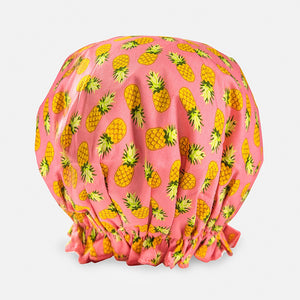Introducing the BOUFFANT SHOWER CAP from BATH ACCESSORIES COMPANY! This stylish shower cap showcases a vibrant design of colorful macarons in shades of pink, purple, yellow, and brown against a lively green background. It features a waterproof inner layer to keep your hair dry and an elasticated bottom for a secure and comfortable fit.