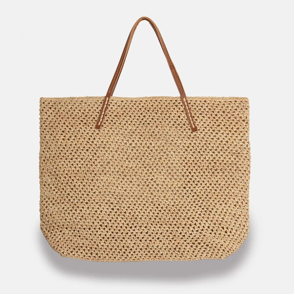 The BEBY LACY RAFFIA TOTE by SANS ARCIDET is a large, wide, rectangular straw tote bag. It features an open-weave design and brown leather-like handles, exuding the perfect summer vibe. The raffia basket is displayed empty against a plain light gray background.