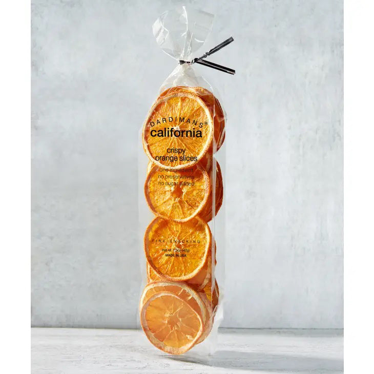 A clear plastic bag of DARDIMANS - CRISPY ORANGE SLICES by DARDIMANS CALIFORNIA CRISPS stands upright on a light surface—vitamin-rich snacks made from premium California oranges.