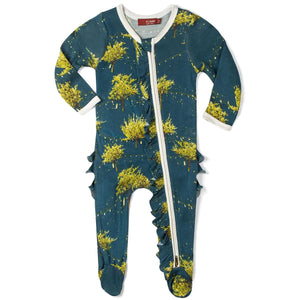 The MILKBARN - FIREFLY RUFFLE ZIP FOOTED ROMPER by MILKBARN is a baby footed romper with long sleeves and footies, featuring a delightful yellow and green tree pattern on a dark green background. Made from breathable bamboo fabric, it boasts a unique diagonal zipper that runs from the neckline down to one of the feet and decorative ruffles along the legs and back.