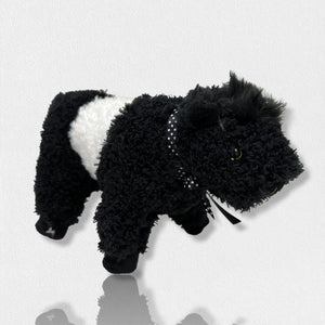 A soft plush toy from the Beverly Hills Teddy Bear Co's Fearrington Signature Collection, resembling a black and white Belted Galloway cow, stands against a plain white background. This furry mascot features black fuzzy fur on its head, legs, and tail, with a white fuzzy band around its midsection, characteristic of the Galloway breed.
