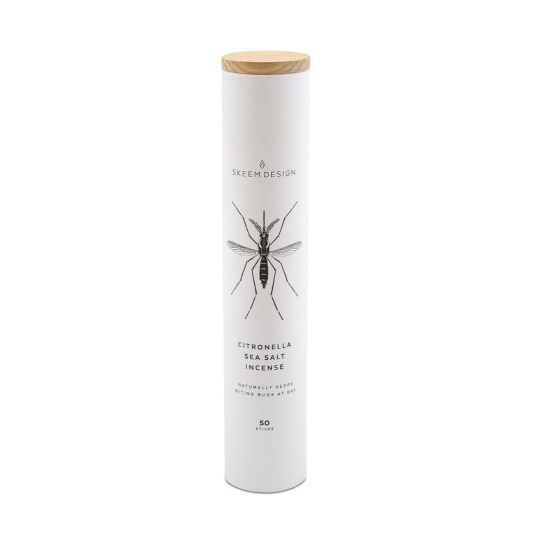 A tall, cylindrical container labeled "Skeem Candles" featuring an image of a mosquito. It reads "Citronella Incense Tube" and "Naturally Keeps Biting Bugs at Bay," with "50 sticks" noted at the bottom. Enhanced with citronella oil, it's perfect for outdoor entertaining. The container is topped with a wooden lid.