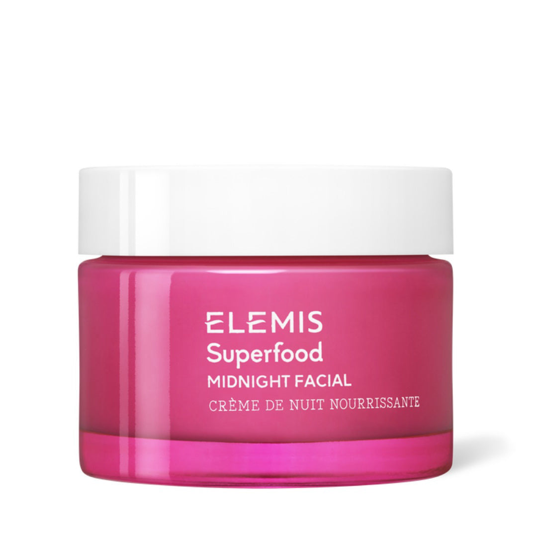 A photograph depicts a vibrant pink jar of ELEMIS - SUPERFOOD MIDNIGHT FACIAL cream by ELEMIS - STEINER, enriched with Vitamin C for nourishing hydration. The jar is topped with a white screw-on lid and showcases the product&#39;s name and description in white text: &quot;Elemis Superfood Midnight Facial Crème de Nuit Nourrissante.