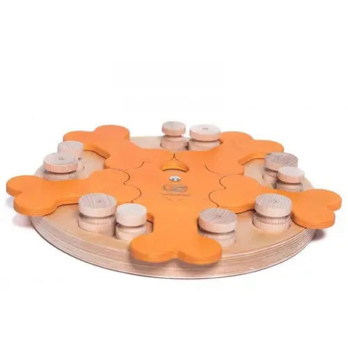 The DOG PUZZLE - CAROUSEL OF BONES by MY INTELLIGENT PETS features a round wooden design with bone-shaped and cylindrical pieces on an orange base. The bone-shaped pieces slide to reveal hidden compartments, while the cylindrical pieces can be moved to different positions. Designed for interactive play, it is a favorite among pet trainers and veterinary professionals.