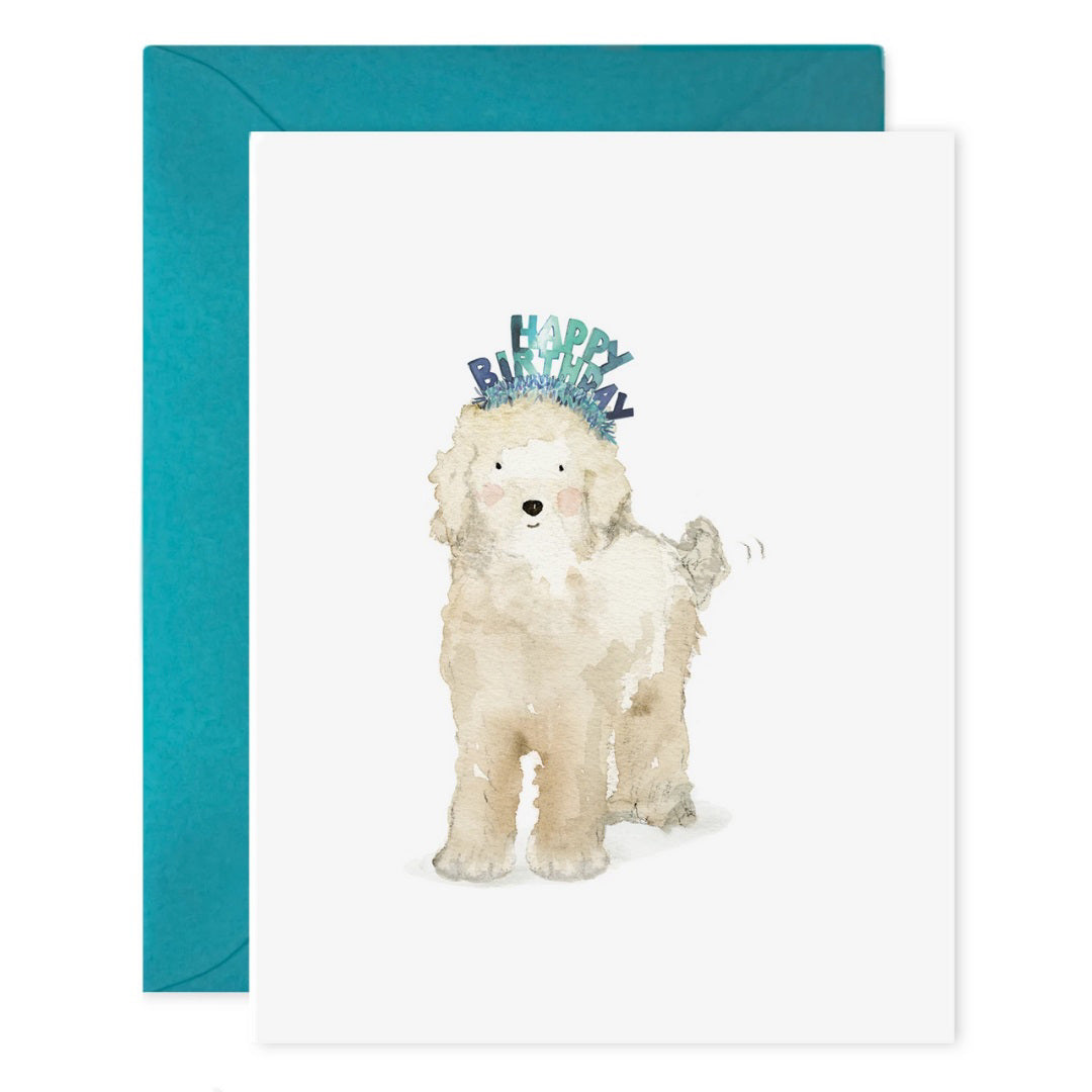 The E. FRANCES PAPER "Lucy Dog Birthday" card features a fluffy white dog in a blue birthday headband, paired with a teal envelope and printed on luxe heavyweight paper.