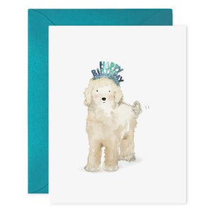 The E. FRANCES PAPER "Lucy Dog Birthday" card features a fluffy white dog in a blue birthday headband, paired with a teal envelope and printed on luxe heavyweight paper.