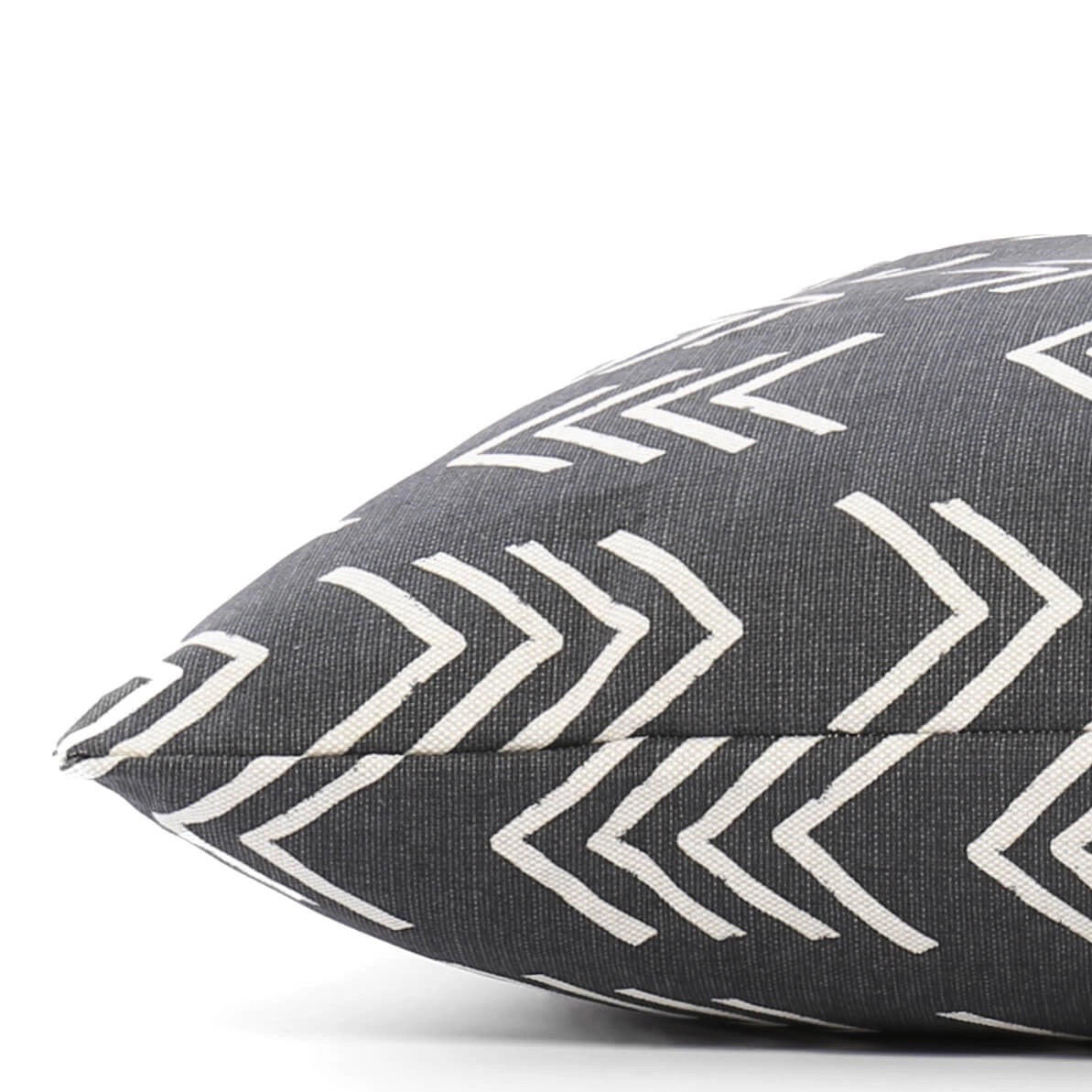 Close-up of The Foggy Dog&#39;s DOG BED (S, MODERN MUD CLOTH BLACK) with a dark gray background and white geometric arrow patterns. The fabric texture is visible, and the pillow is positioned at an angle, showcasing the stitching. Made in the USA with an eco-friendly insert, this boho minimalist dog bed adds style to any space.