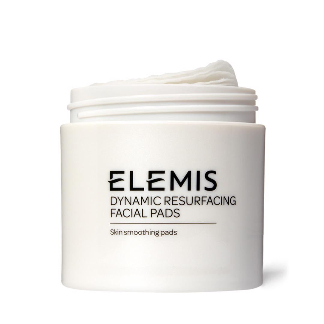 A container of ELEMIS - DYNAMIC RESURFACING FACIAL PADS 60PK from ELEMIS - STEINER is displayed against a white background with its lid off, showcasing the round exfoliating pads inside. The label reads "Skin smoothing pads," emphasizing the Tri-Enzyme Technology and Lactic Acid for optimal skin renewal.
