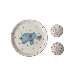 Introducing the TOOTH AND LOCK ELEPHANT (PINK) by ANN MARIE MURRAY, L.L.C., a bespoke porcelain set that includes a beautifully crafted plate and two small lidded containers. The plate showcases a hand-painted blue elephant with pink ears playing with a colorful ball, all surrounded by charming pink polka dots. The dotted lidded containers are thoughtfully labeled "first lock" and "first tooth.