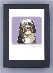 The PAPER RUSSELLS - TIBETAN TERRIER BOXED CARDS feature a cheerful black and white dog with its tongue out on a purple background. The design is printed on recycled paper, framed with a white border, and encased in a dark frame.