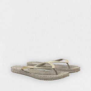 The ILSE JACOBSEN - CHEERFUL SLIPPER IN ATMOSPHERE by LINES OF DENMARK is a pair of lightweight beige flip-flops featuring textured soles and thin straps with subtle metallic gold accents, adorned with delicate glitter stones. These stylish flip-flops are displayed on a white, textured surface.