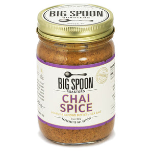 A 13-ounce (368-gram) jar of BIG SPOON ROASTERS - CHAI SPICE PEANUT ALMOND SEA SALT NUT BUTTER features a gold lid and a white label with purple accents. The label highlights that the nut butter is handcrafted from a Masala Chai blend with peanuts, almonds, and sea salt.