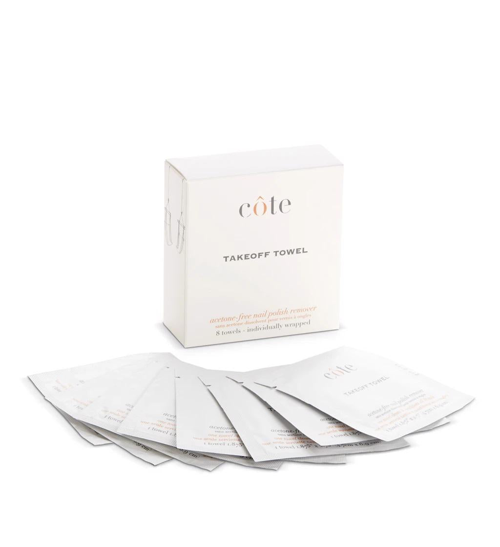 A box labeled "COTE - TAKE OFF TOWELS - POLISH REMOVER" is displayed with individually wrapped white packets laid out in a fanned arrangement in front of it. The packaging mentions that the product is a travel-friendly, acetone-free nail polish remover.