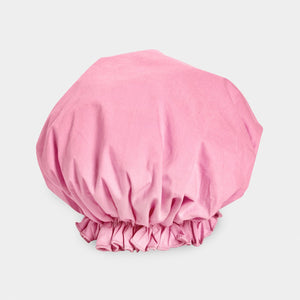 Introducing the BOUFFANT SHOWER CAP from BATH ACCESSORIES COMPANY! This stylish shower cap showcases a vibrant design of colorful macarons in shades of pink, purple, yellow, and brown against a lively green background. It features a waterproof inner layer to keep your hair dry and an elasticated bottom for a secure and comfortable fit.
