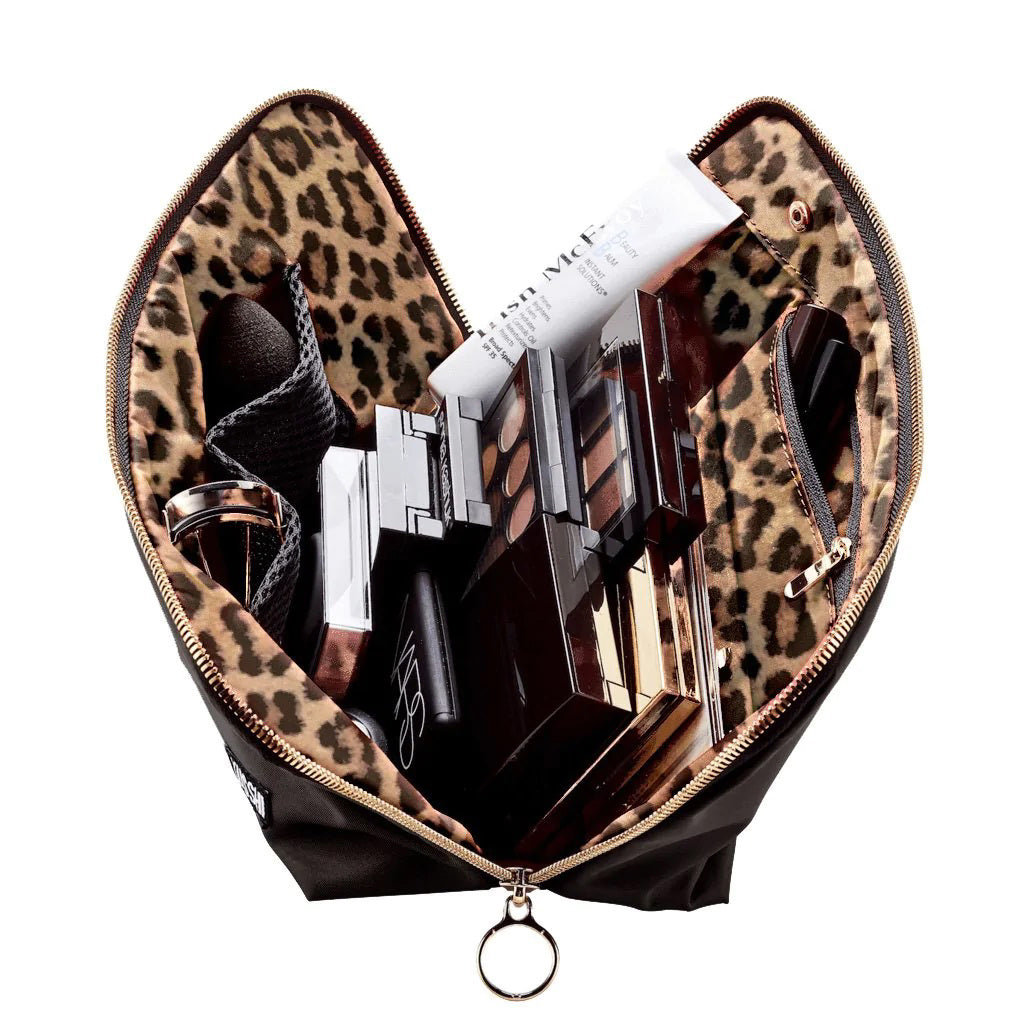 Presenting the KUSSHI - Signature Makeup Bag in Black: a stylish, zippered makeup bag with a rectangular shape and a slightly curved top. The pouch is adorned with two gold zipper pulls and features a small rectangular label with &quot;KUSSHI&quot; written in white letters on the bottom right corner. It offers spacious compartments and is conveniently machine washable for easy care.