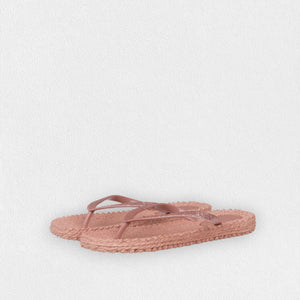 A pair of comfortable ILSE JACOBSEN - CHEERFUL FLIP FLOPS IN MISTY ROSE by LINES OF DENMARK, featuring braided straps adorned with glitter stones and textured soles. The background is a plain white surface. The flip-flops are angled slightly to the left, with the front pair overlapping the toe area of the back pair.