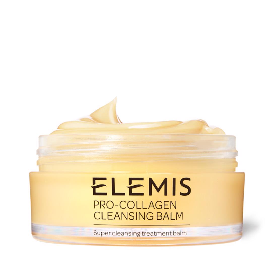 A jar of ELEMIS - PRO-COLLAGEN CLEANSING BALM by ELEMIS - STEINER, featuring a smooth, creamy texture. The yellow jar with black text has its lid off, revealing the nourishing cleansing balm inside. The text on the jar reads, &quot;Super cleansing treatment balm.&quot; Ideal for makeup removal and infused with essential oils.