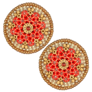 A circular decorative brooch from the Miguel Ases Collection showcases intricate beadwork in a stunning radial pattern. At its center is a gold design, encircled by red beads and bordered by alternating gold and beige beads. The entire piece, set against a plain white background, exudes the same elegance found in MIGUEL ASES - SWAROVSKI MIYUKI RONDELLE EARRINGS by MIGUEL ASES, INC.