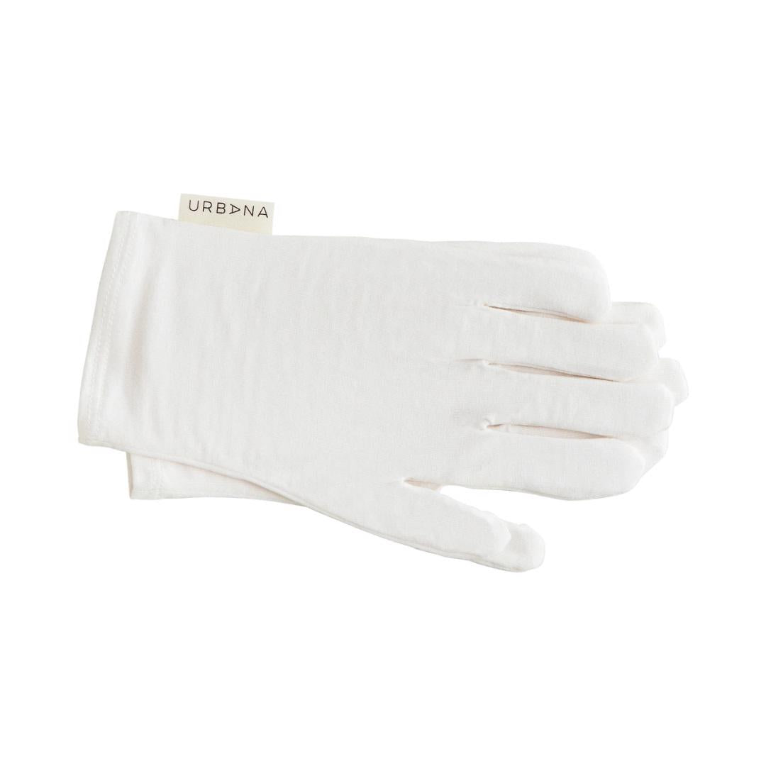 A pair of white MOISTURIZING GLOVES from EUROPEAN SOAPS, LLC are neatly stacked one atop the other. A small fabric label on the wrist reads "Urbana" in black text. The gloves are simple in design with a smooth texture and are positioned against a plain white background.