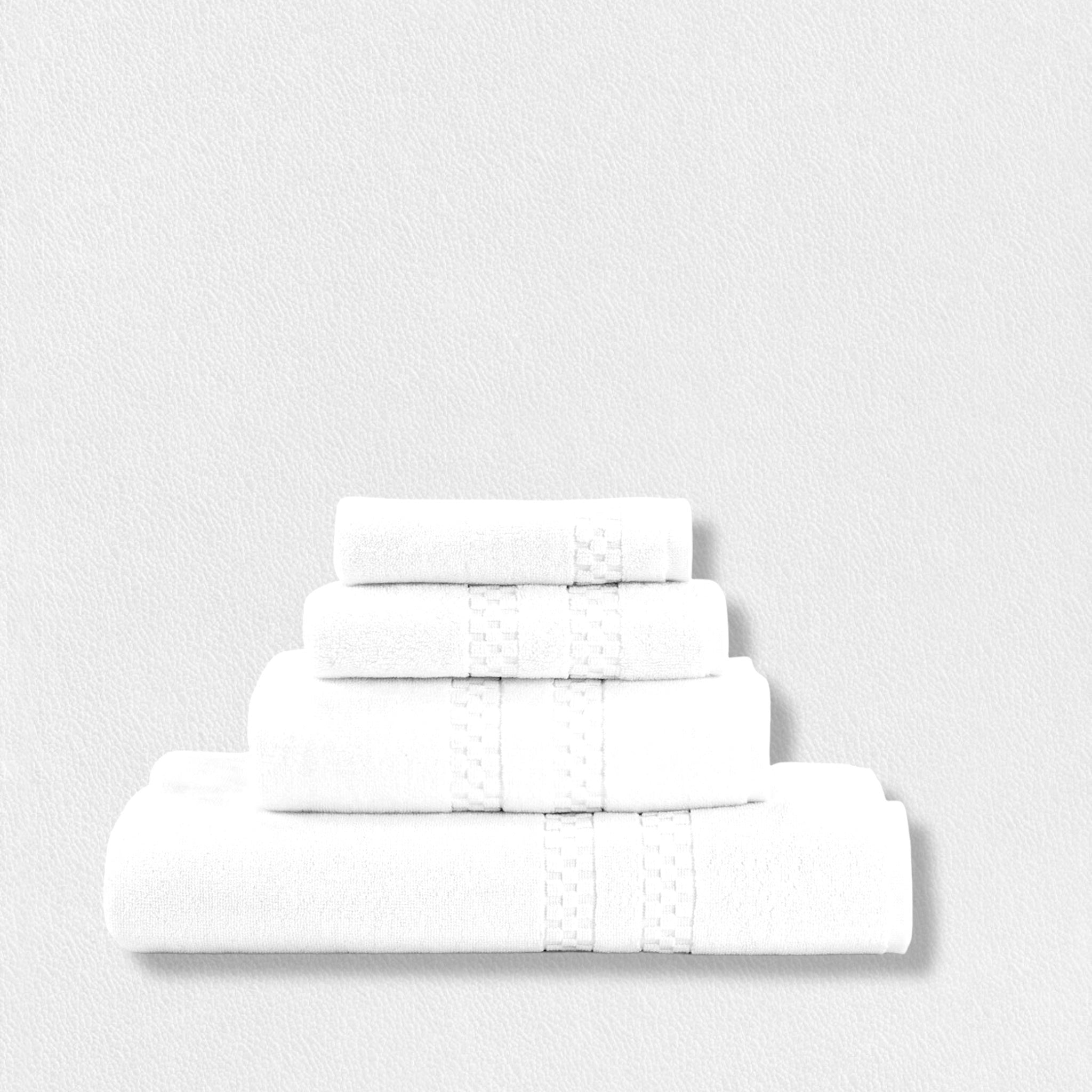 Four neatly folded white towels of varying sizes are stacked on top of each other against a plain white background. Each towel has a subtle decorative band near the edge.