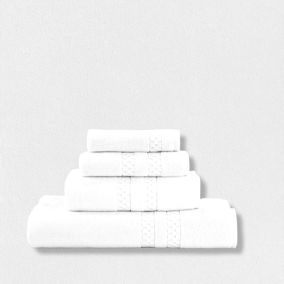 Four neatly folded white towels of varying sizes are stacked on top of each other against a plain white background. Each towel has a subtle decorative band near the edge.