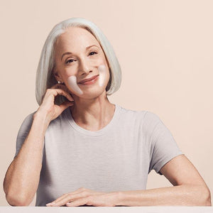 The image shows a product package labeled "SIO EYE AND SMILE" by SIO BEAUTY. The package contains "SIO Eye & Smile Lift Reusable Wrinkle-Smoothing Patches." Made from medical-grade silicone, these patches target fine lines and wrinkles around the eyes and laugh lines. Next to the package, two white, crescent-shaped patches are displayed on a light pink background.