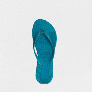 A pair of ILSE JACOBSEN - Cheerful Flip Flops in Veridian Green with textured soles and thin straps is placed against a plain white background. Known for their comfortable fit, the flip-flops by Lines of Denmark are slightly overlapping, with one tilted on top of the other.