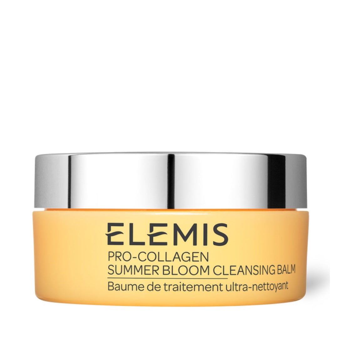 A round, yellow jar of ELEMIS - PRO-COLLAGEN SUMMER BLOOM CLEANSING BALM from ELEMIS - STEINER, featuring a silver lid. The label on the jar bears French text &quot;Baume de traitement ultra-nettoyant,&quot; emphasizing its Summer Bloom fragrance and effectiveness as a makeup remover.