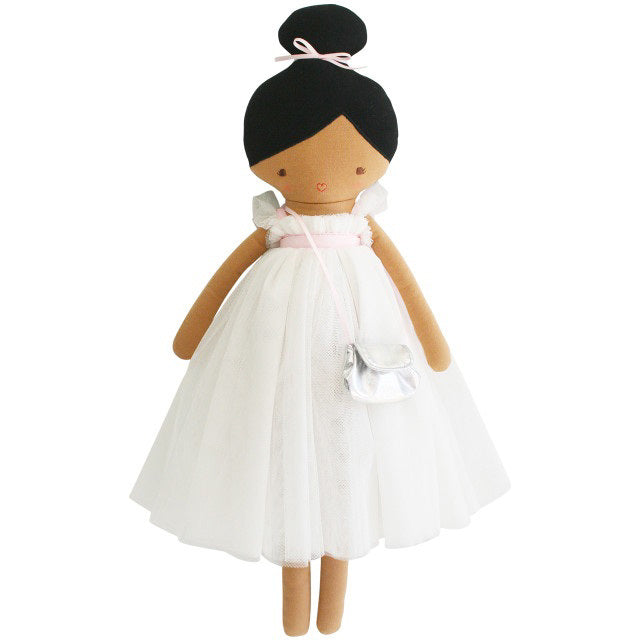 Introducing the ALIMROSE - CHARLOTTE DOLL IVORY by ALIMROSE: A charming plush doll featuring black hair styled in an elegant bun, adorned in a tulle dress with a pale pink ribbon belt. Complemented by a silver bag slung over one shoulder, this delightful doll showcases an embroidered face with simple stitched eyes and a small red smile.
