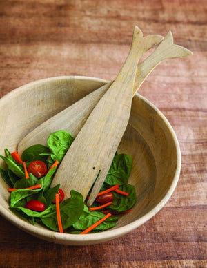The CORISSA BOWL - LARGE by BE HOME, INC is a hand-carved, round bowl made from sustainably sourced Raw Mango Wood, featuring a smooth matte finish and light wood color, displayed on a neutral gray surface against a plain background.