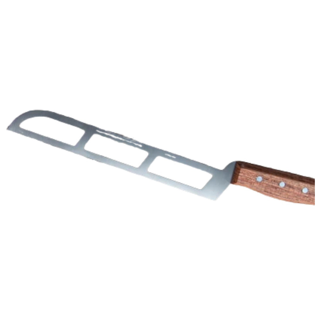 A handmade PRO SOFT CHEESE KNIFE with a cut-out design and the brand name &quot;FORMATICUM&quot; etched on its stainless steel blade is placed on a wooden cutting board. A partially sliced piece of cheese rests next to this professional cheese knife, crafted in Italy.