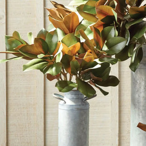 The NAPA HOME AND GARDEN - GRAND MAGNOLIA LEAF STEM, with its versatile green and brown leaves, beautifully complements any tablescape against a plain white background.