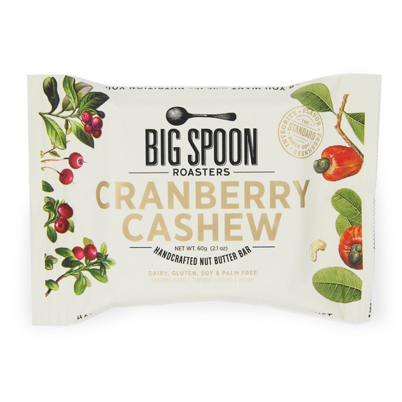 A package of BIG SPOON ROASTERS Cranberry Cashew Snack Bar. The packaging displays cranberries, cashews, and cocoa nibs against a white background, with text indicating it is gluten-free, dairy-free, soy-free, and palm oil-free and weighs 60 grams (2.1 oz).