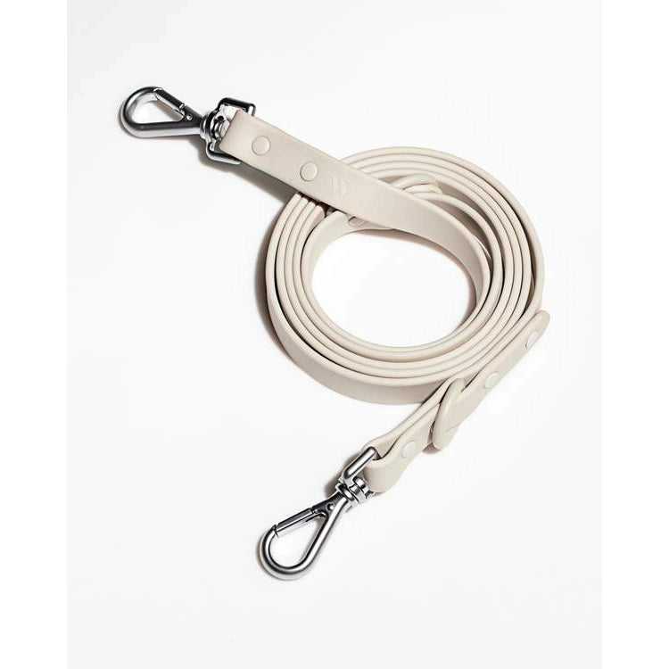 Experience the sleek design of the Wild One DOG LEASH (S, GREY). Made from dirt and odor-resistant material, this modern coiled leash features flex-poly straps and rivet accents near the sturdy metal clips at both ends, perfect for attaching to a collar or harness.
