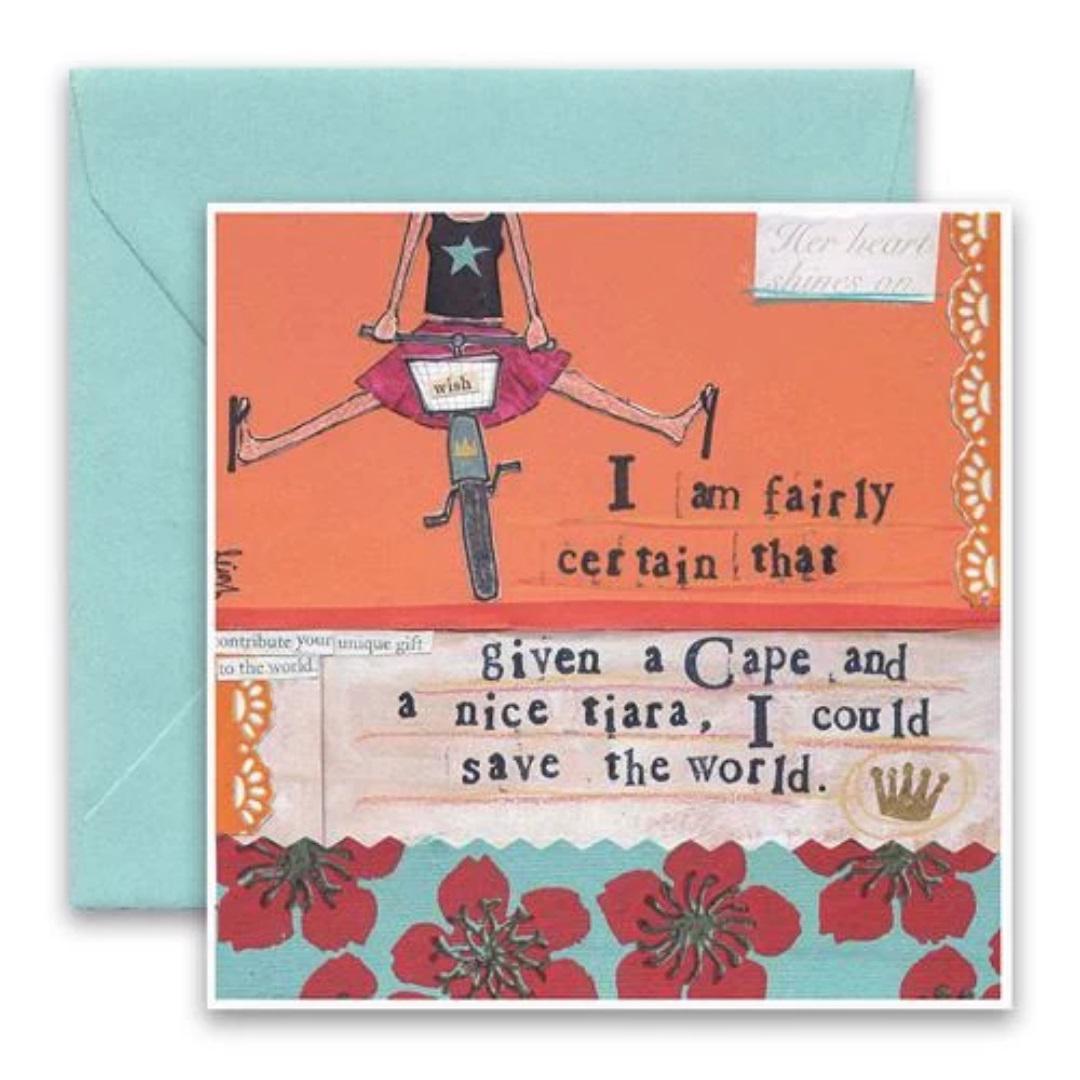 The CURLY GIRL DESIGNS - CAPE AND TIARA CARD by CURLY GIRL DESIGN, INC features a vibrant illustration of a person riding a bike, dressed in a star shirt and pink skirt. The text reads, "I am fairly certain that given a Cape and a nice tiara, I could save the world." This charming collage art card comes paired with a light blue envelope.