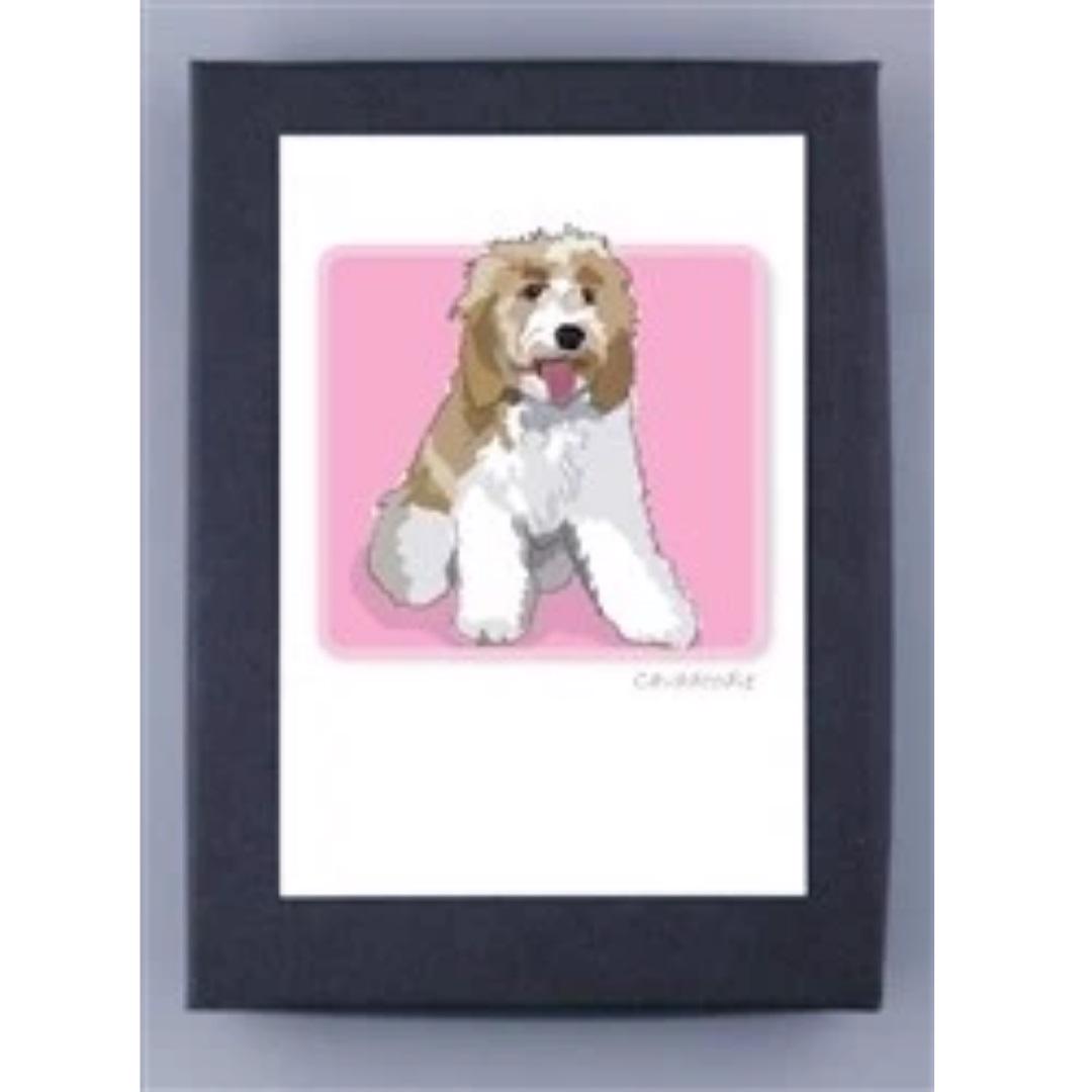 The CAVADODDLE NOTE CARDS from PAPER RUSSELLS feature an illustration of a dog with white and light brown fur, happily panting with its mouth open and tongue out, set against a pink background. The artwork, framed with a black border, is printed on recycled paper and proudly made in the USA.